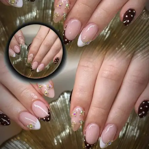 Nageldesign: Nude-Mandelnägel mit weißer French-Spitze, Gold-Akzenten und braunen Punkten