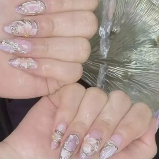 Nageldesign: Mandelnägel in Flieder-Chrome mit Blüten, Perlen und Gold-Akzenten